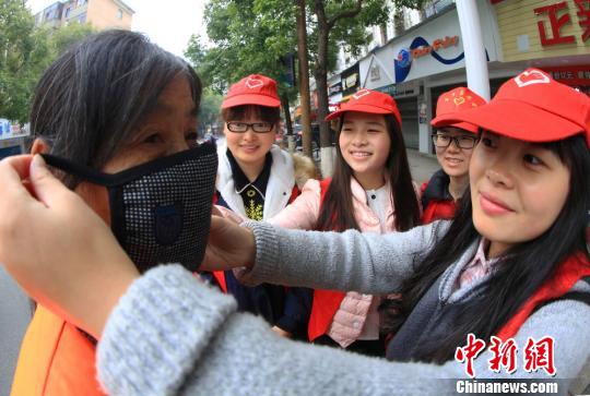 湖南高校青年志愿者给环卫工人戴口罩保暖抗霾
