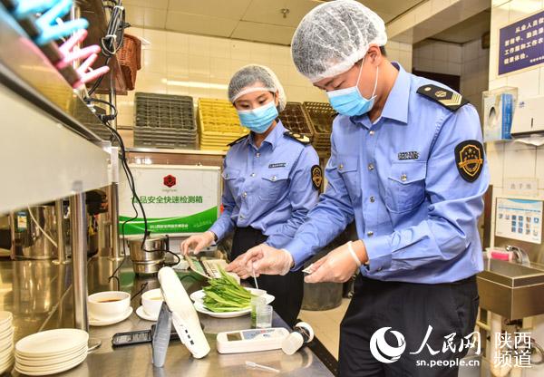 西安市食药监局工作人员正在对食品进行快速检验检测