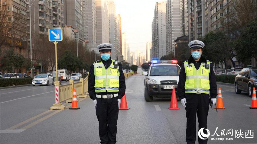 西安交警雁塔大队民警在南三环朱雀大街十字管控第一道防线。