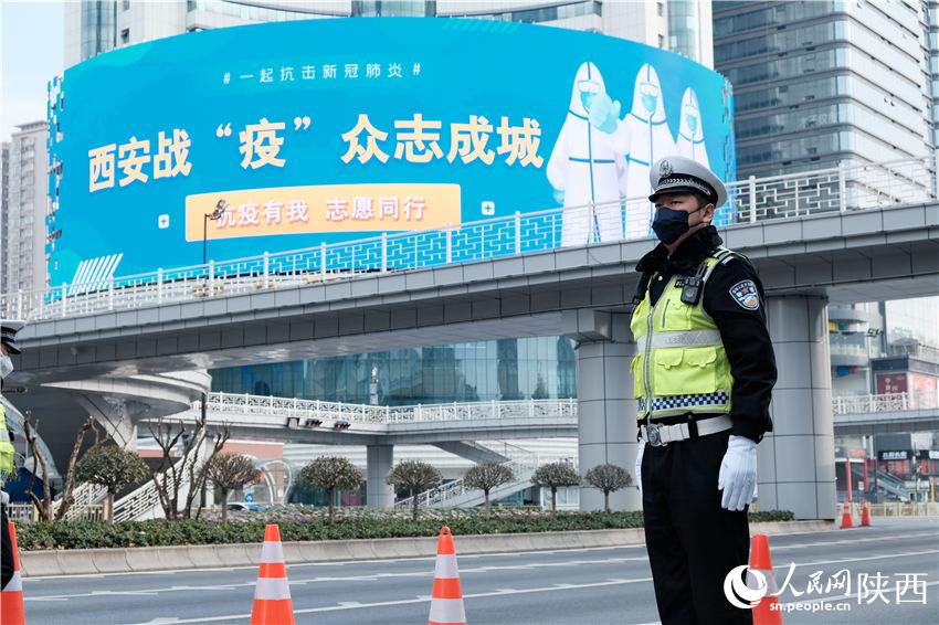 12月28日下午，西安市长安路主干道上，车辆稀少。西安交警在小寨、南门、北大街等位置设置防控点位，24小时对双向车辆进行检查。人民网记者吴超 摄