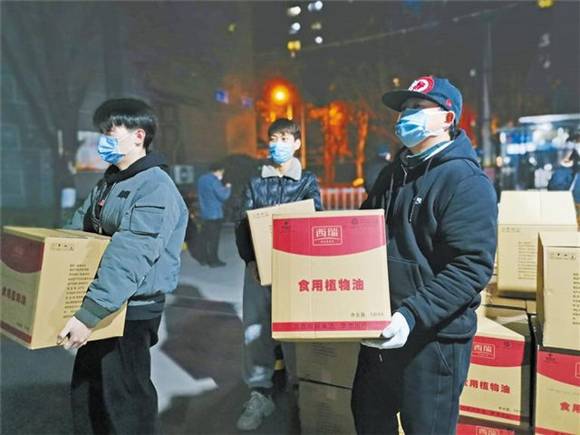 1月1日晚,胡家庙街道天赐良苑小区志愿者为住户搬运米面油.