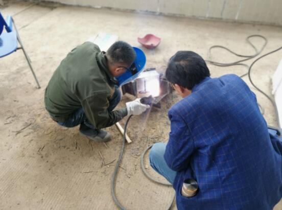 图为老师（右一）为电焊工学员何兆荣（左一）1对1操作讲解。汉中市人社局供图