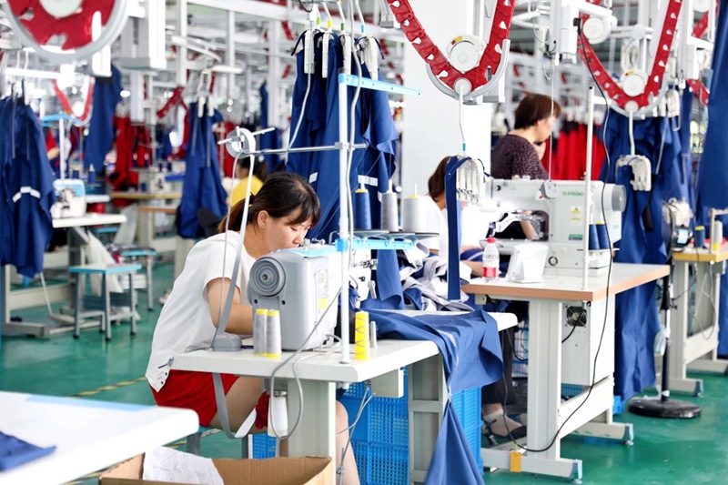 8月5日，陝西北方核防護科技有限公司裡，工人正在使用縫紉機制作衣服。吳凱攝
