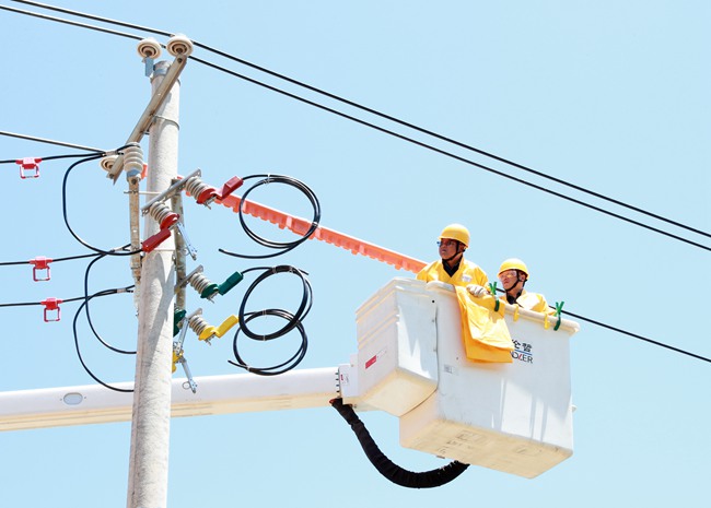 國網陝西電力銅川供電公司配網帶電作業人員冒高溫帶電搭接刀閘上引線，保障企業用電需求，助力鄉村振興發展。