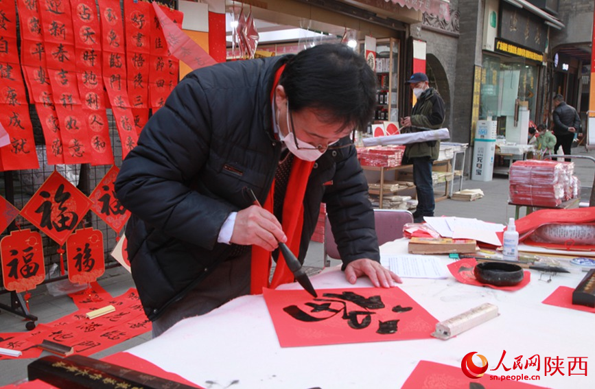 书院门步行街内，摊主正在为顾客写“福”字