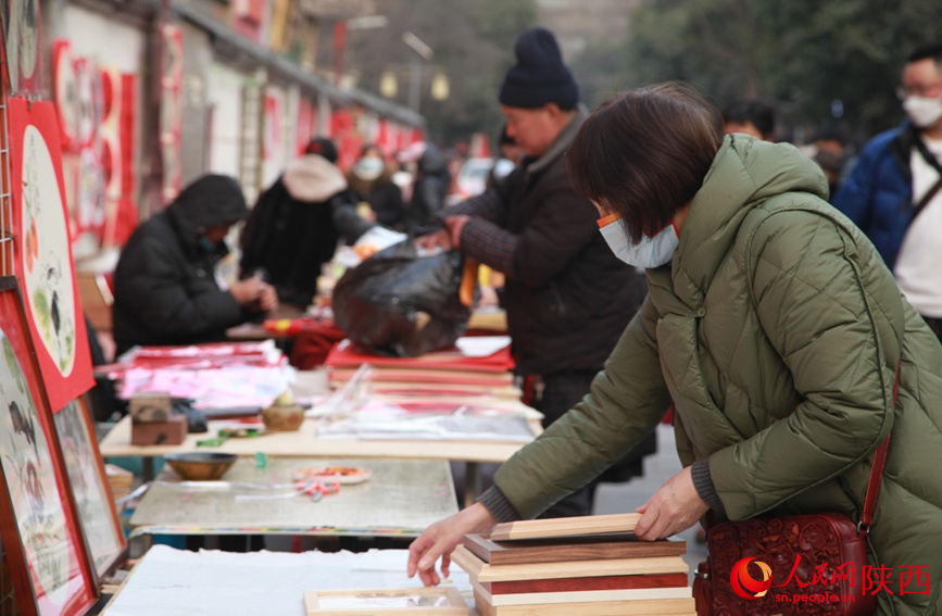 西安书院门步行街内，市民正在挑选新年装饰画