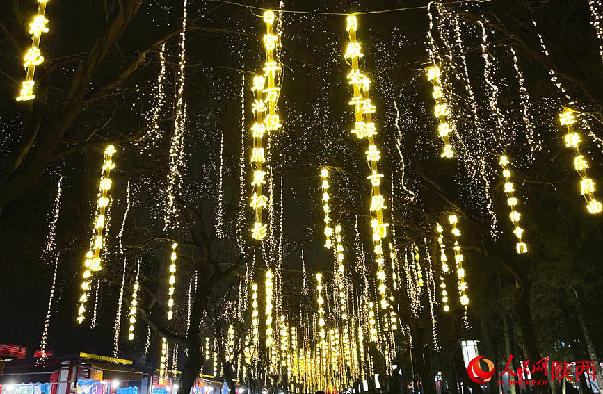 陝西西安大雁塔步行街兩側挂滿詩詞燈飾 。