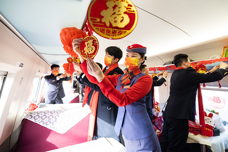 西安北至深圳北G824次列車，高鐵和地鐵乘務員一起貼窗花、挂福聯打造迎新年聯歡車廂。劉翔 攝