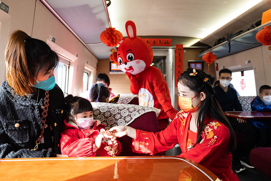 西安北至深圳北G824次列车，高铁乘务员装扮成“嫦娥”为小旅客赠送兔年主题挂饰。刘翔 摄