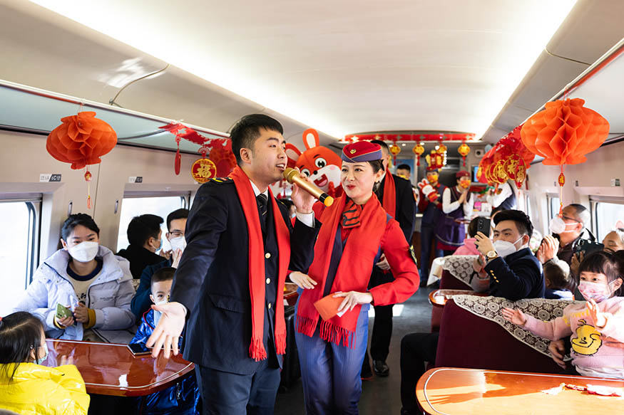 西安北至深圳北G824次列车，高铁和地铁乘务员在车厢内载歌载舞为旅客送上新年祝福。刘翔 摄