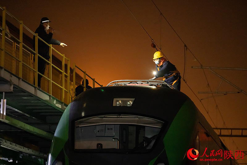 1月26日，西安客车车辆段，铁路检修“小哥”们正在检查动力集中型动车组车顶高压电器。刘翔摄