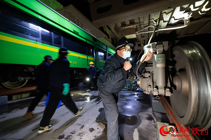 1月26日，西安客车车辆段，铁路检修“小哥”正在检查动力集中型动车组走行部件。刘翔摄