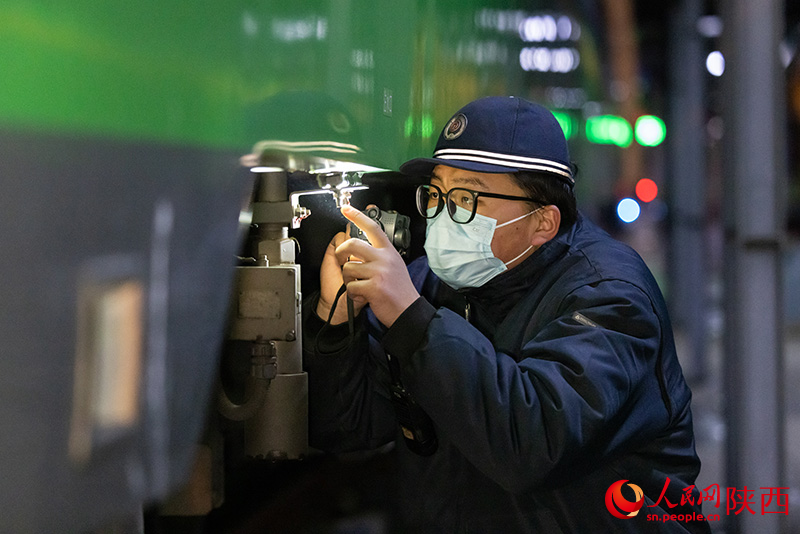 1月26日，西安客车车辆段，铁路检修“小哥”正在检查动力集中型动车组注水口保证旅客正常用水。刘翔摄