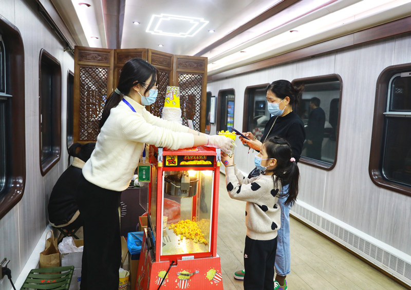 旅客们在列车上购买爆米花。敬雨桥摄