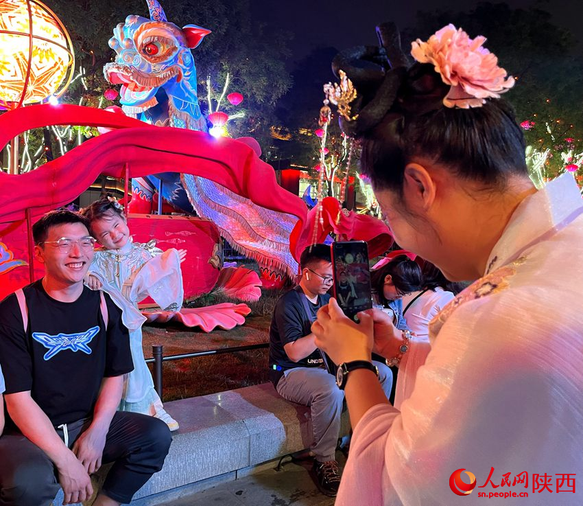 游客在大唐不夜城景區內拍照留念。人民網魏鑫 攝