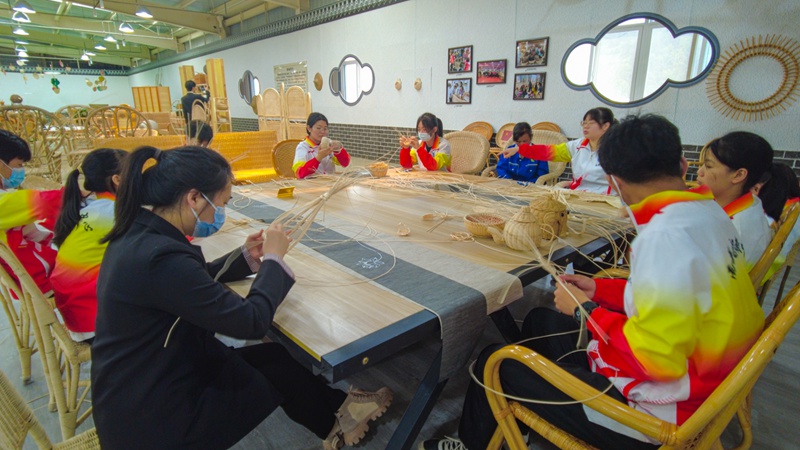 附近学生来到工厂体验学习编织文化。