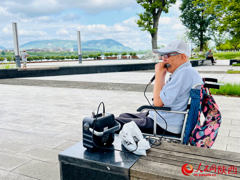 94歲的張大爺每天都會到天漢濕地公園憩息吹口琴。人民網記者 孫挺攝