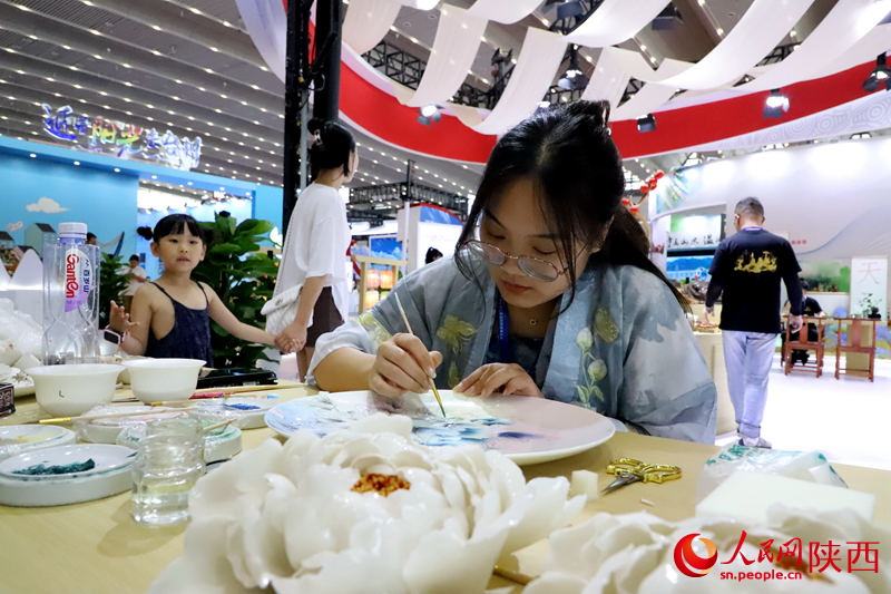 交流合作馆内游客体验绘制牡丹瓷。人民网记者 孙挺摄