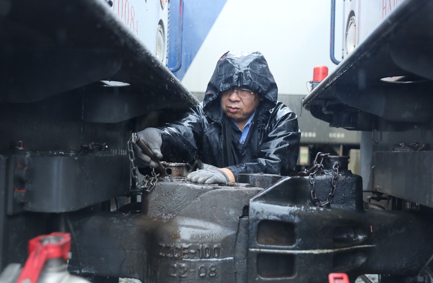 安康機務段庫內，調車員在雨中進行機車連挂作業。劉衛東攝