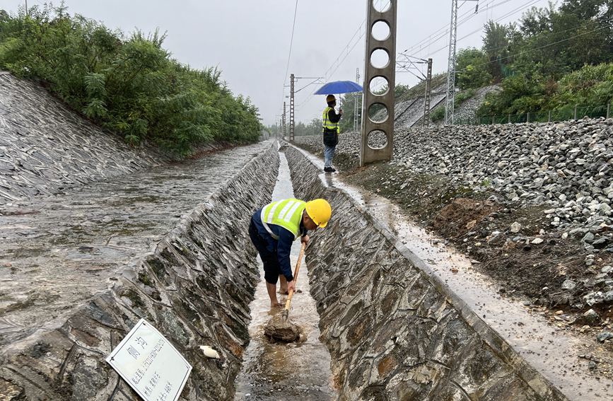 漢中工務段西鄉線路車間防洪人員在陽安線西鄉至沙河坎區間清理水溝。金嶸攝