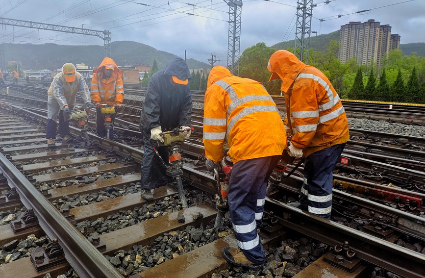 延安工務段職工雨中對線路幾何尺寸不良處所進行整治。劉一帆攝