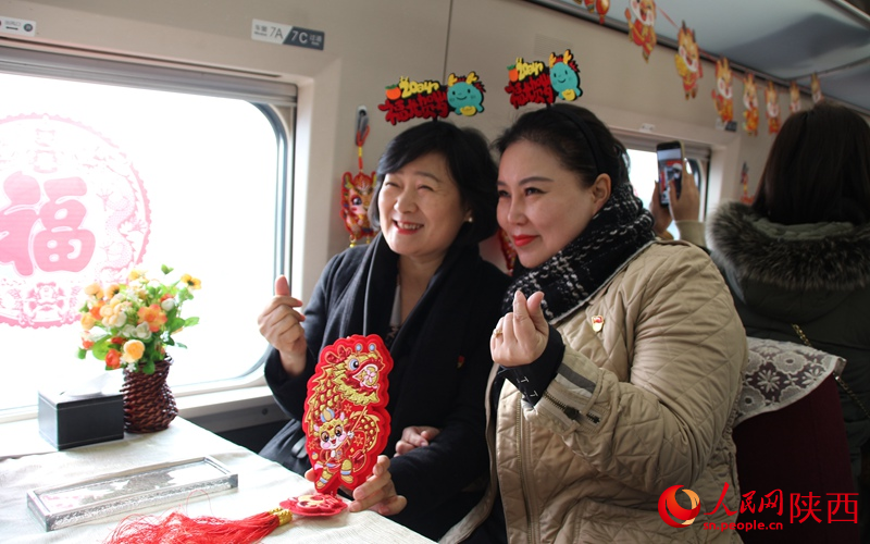 旅客们在列车内拍照打卡，喜迎新春。人民网记者 贾凯璐摄