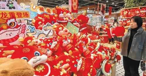 近期，西安多家商场销售龙年吉祥物。图为2月12日，游客在商场挑选商品。（杜玮摄）