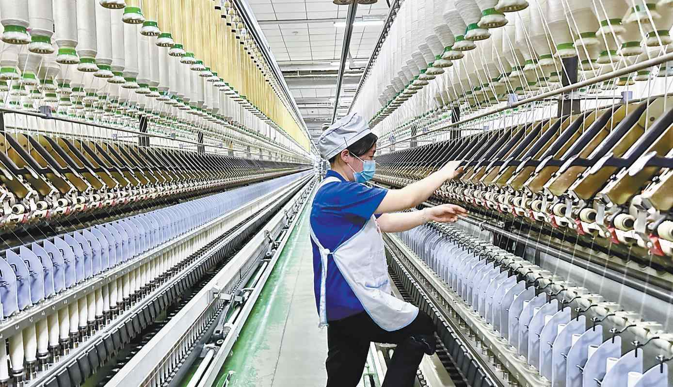 二月十八日，在咸阳纺织集团有限公司一分厂细纱车间，纺织女工在进行接头、换粗纱等工作。 记者 琚鹏飞摄