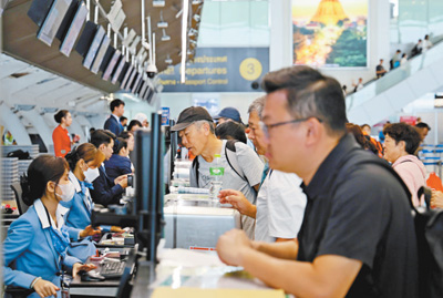 春节期间，中国游客在泰国曼谷素万那普机场办理登机手续。本报记者 白元琪摄