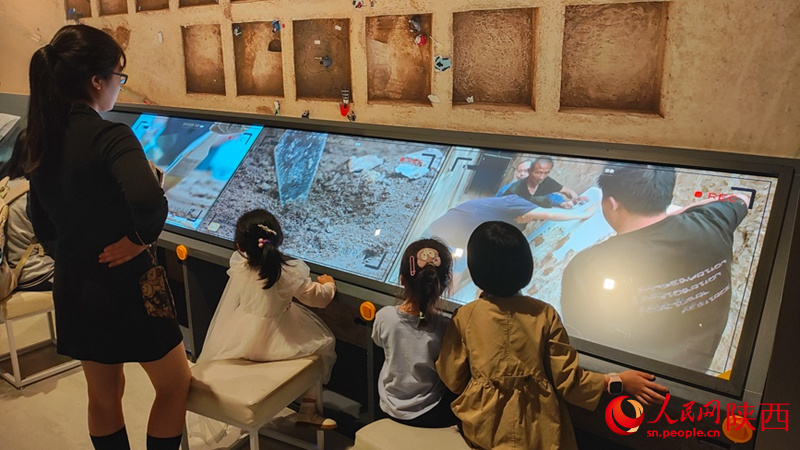 家長帶領孩子觀看考古紀錄影像。人民網 黨童攝