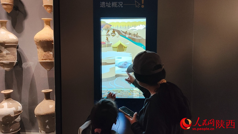 游客引导孩子与介绍屏互动。人民网 党童摄