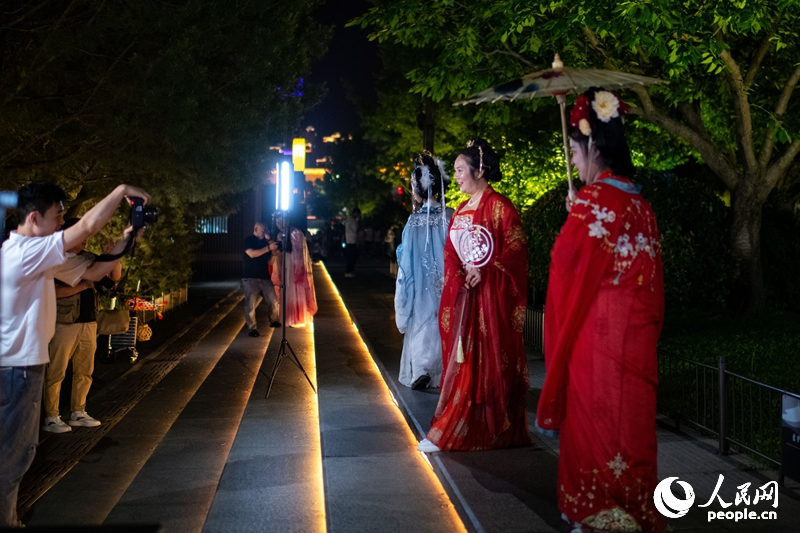 在西安大唐不夜城景区，身着汉唐服饰的游客正在拍摄写真。人民网记者 翁奇羽摄