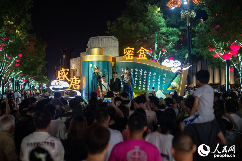 在西安大唐不夜城步行街，游客正在观看互动表演。人民网记者 翁奇羽摄