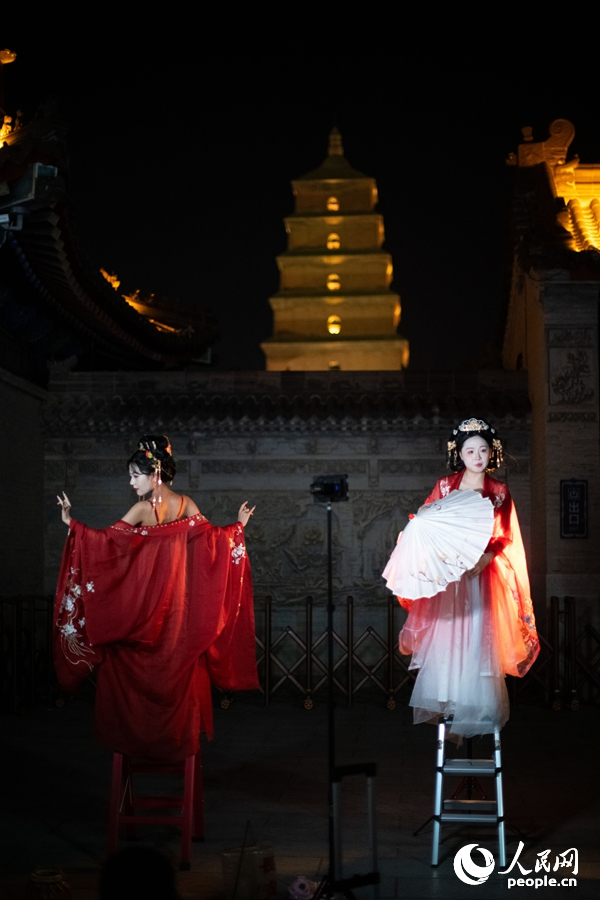 在西安大唐不夜城景区，身着汉唐服饰的游客正在拍摄写真。人民网记者 翁奇羽摄