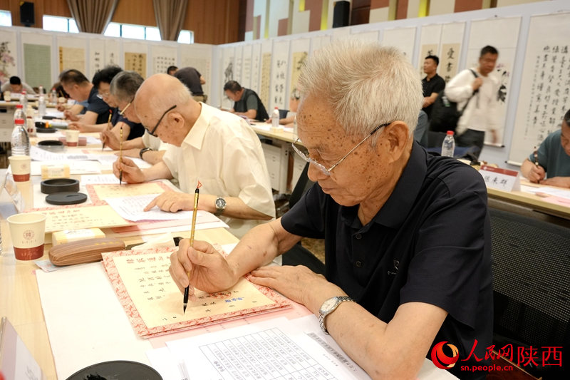 退休教师用毛笔书写2024级新生录取通知书。人民网记者 贾凯璐摄