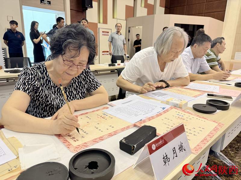 退休教师用毛笔为今年新生手写录取通知书。人民网记者 贾凯璐摄