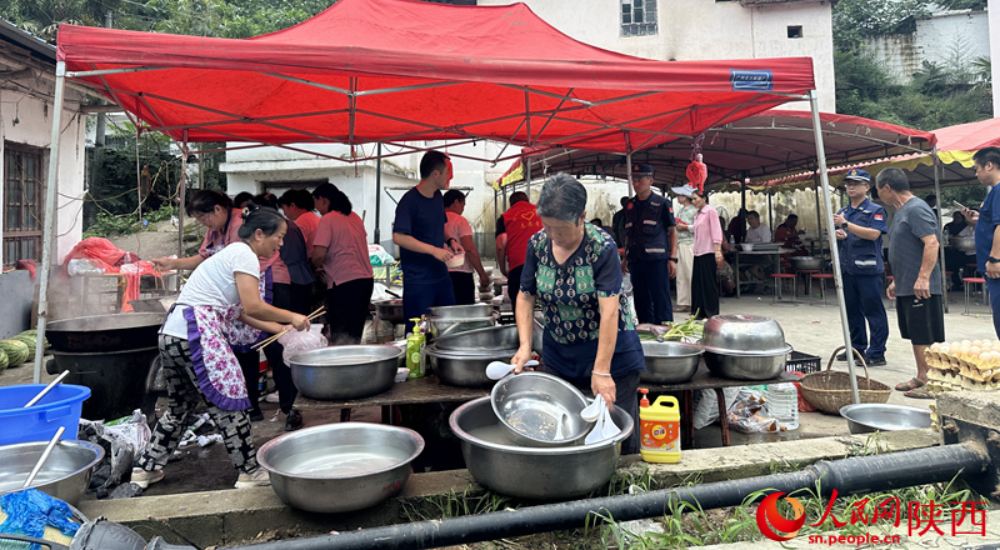 村民在应急救援服务点为救援人员做后勤保障工作。人民网记者 李志强摄