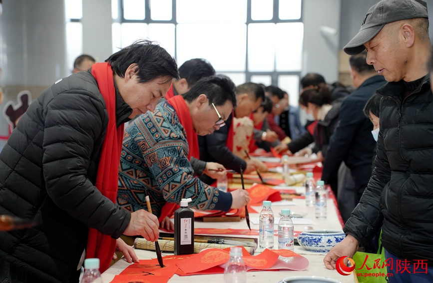 西安站内“万福迎春”活动吸引许多旅客排队领取手写对联。人民网记者 贾凯璐摄