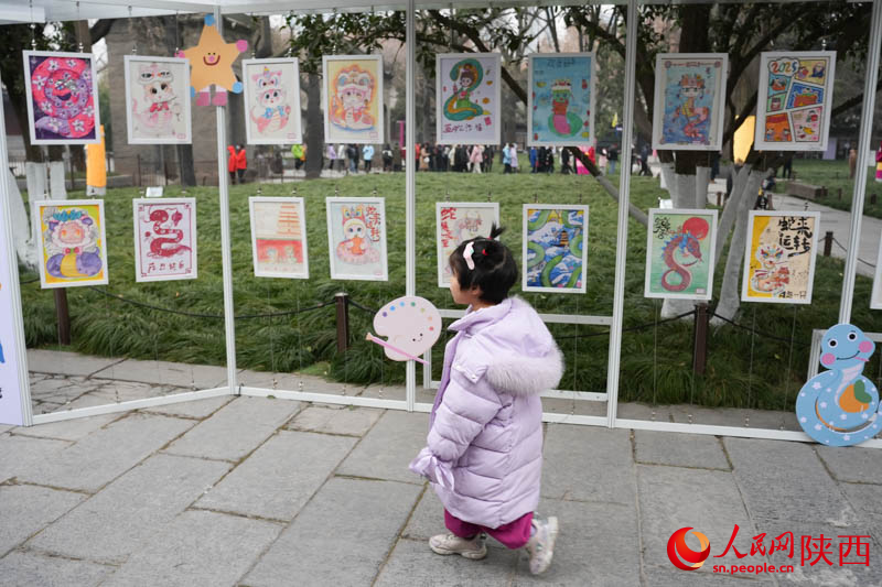 展出的蛇年主题绘画作品吸引了不少“小游客”驻足观看。人民网记者 李志强摄