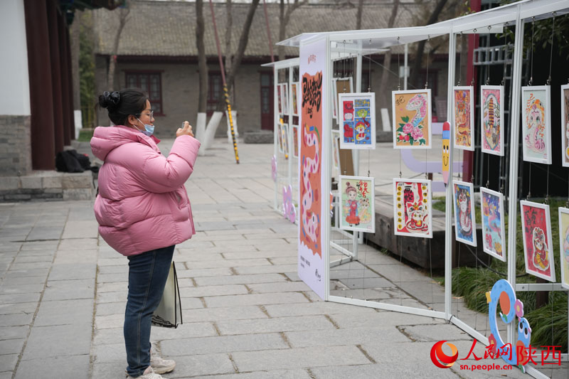 游客在观看展出的蛇年主题绘画作品。人民网记者 李志强摄