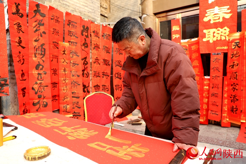 書法愛好者在書院門步行街揮毫潑墨，書寫春聯。人民網記者孫挺 攝