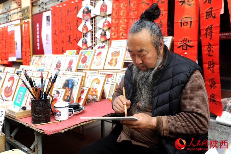 書院門步行街攤主正在繪制蛇年畫作。人民網記者 孫挺攝