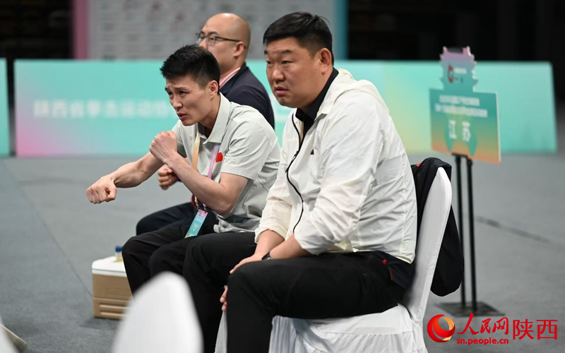 场边，教练组的成员们紧紧盯着场上选手的表现。人民网记者 白鸽摄