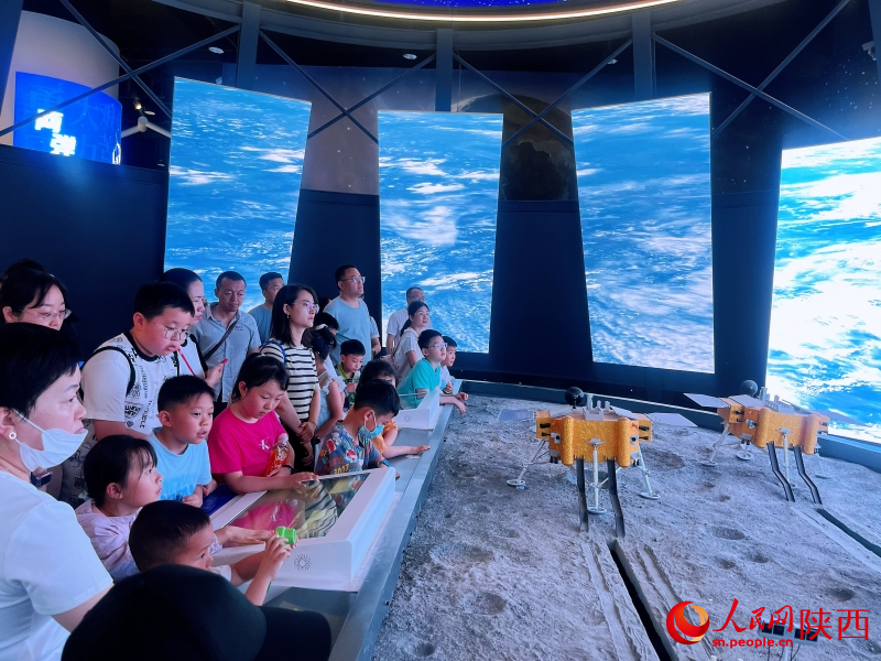“逐梦空天”展区，市民游客在观看探月科教视频。人民网记者 魏鑫摄