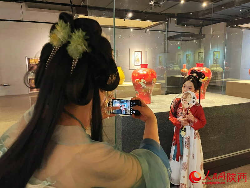 在陶瓷（艺）馆，身着汉服的女子在给孩子拍照留念。 人民网记者 魏鑫摄