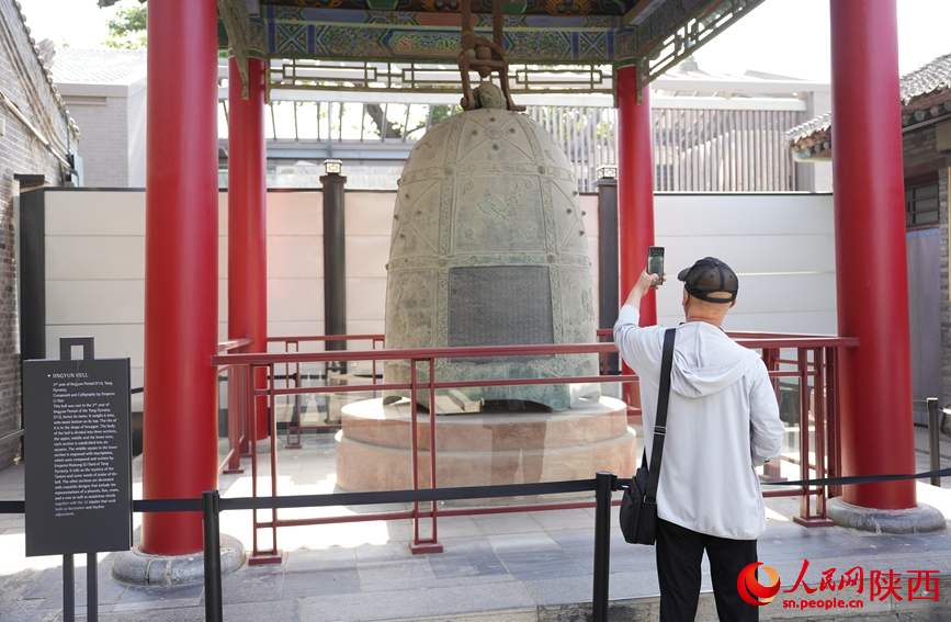 游客在國寶級文物“景雲鐘”前拍照“打卡”。人民網記者 李志強攝