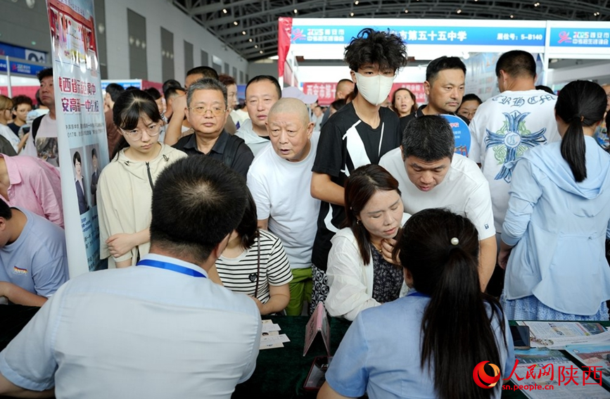 西安中招會現場,學校招生老師認真詳細為家長考生答疑解惑。人民網記者 孫挺攝