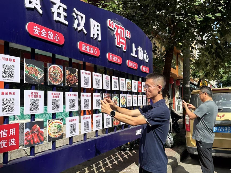 漢陰縣榮盛街頭，顧客食客隻需掃碼即可觀看對應餐飲店后廚實況視頻。漢陰縣融媒體中心供圖
