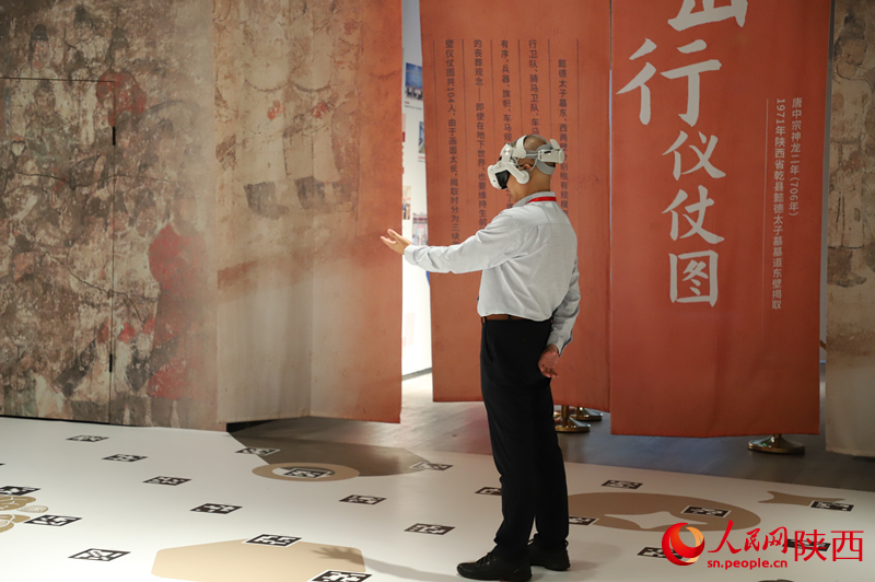 一名《壁画那边是唐朝》项目的体验者正在和剧情互动。人民网记者 李志强摄