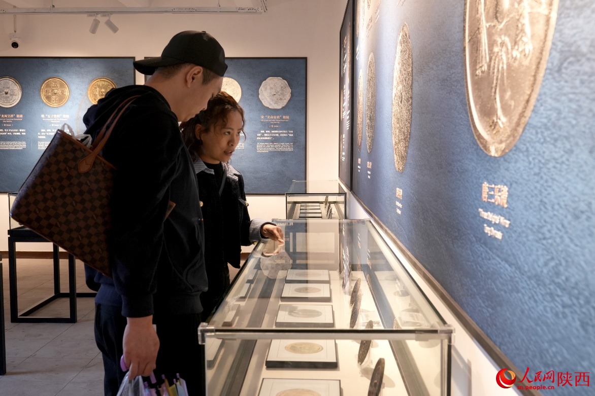 游客在35号敌楼古代青铜镜展馆内参观。人民网记者 白鸽摄